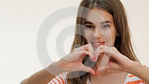 Young woman showing heart shape gesture