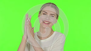 Young Woman showing Heart Shape by Hands on Green Background