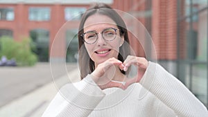 Young Woman showing Heart Shape by Hands, Outdoor