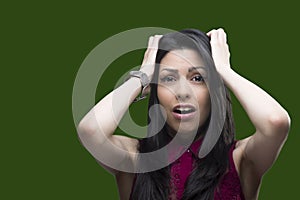 Young woman showing her fear towards someone over a green screen that can be replaced by any background. photo