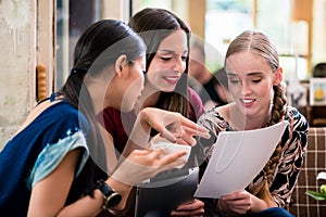 Young woman showing paperwork to her friends