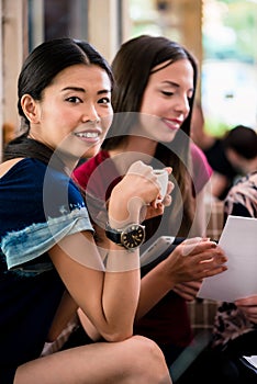 Young woman showing paperwork to her friends