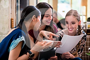 Young woman showing paperwork to her friends