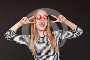 Young woman showing peace sign in studio