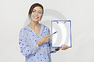 Young woman showing report on clipboard against white background