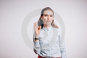 Young woman showing several expressions, shows gesture OK