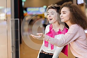 Young woman showing something in the shop window to her husband