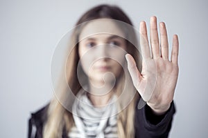 Young woman showing stop gesture open palm hand