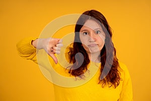 Young woman showing thumbs down.