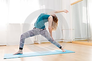 Young woman showing variation of high lunge pose