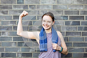 Young woman shows her arm muscles