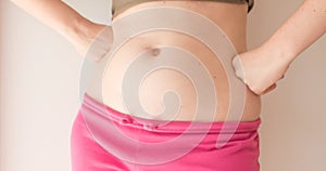 A young woman shows moles on her stomach. Birthmark concept