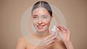 Young woman shows off a bottle with a foam dispenser for washing