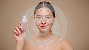 Young woman shows off a bottle with a foam dispenser for washing