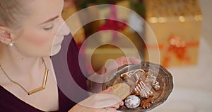 Young woman shuffling various fresh cookies in plate