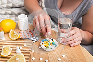 Young woman sick with colds and flu, self-medication at home with vitamins and pills