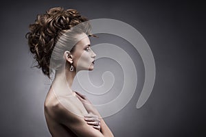 Young woman side beauty portrait on grey background