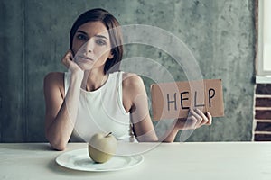 Young Woman with Sign Help and Eating One Apple.