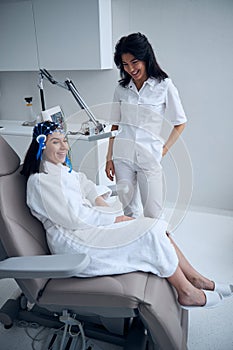 Young woman in a silicone cap smiling during the EEG