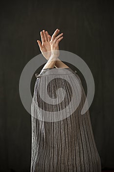 Young woman in silver dress dancing in the studio.