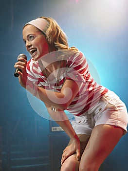 Young Woman Singing Into Microphone