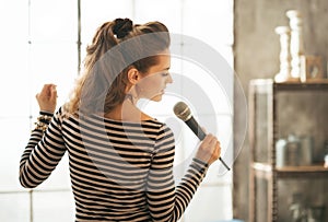 Young woman singing with microphone