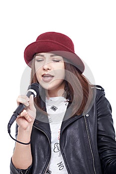 A young woman singing with a microphone wearing a white t-shirt