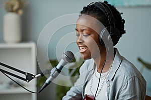 Young Woman Singing to Microphone in Home Studio