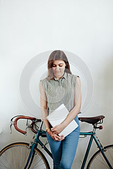 Young woman sipping coffee or tea and reading magazine