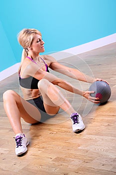 Young woman sit up with ball