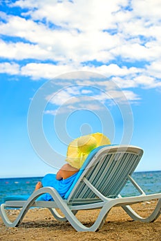 Young woman sits in the chaise lounge photo