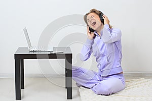 Young woman sits on the floor and listening music