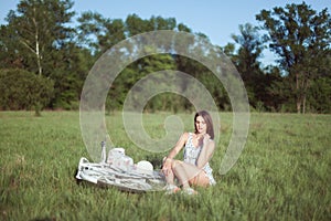 Young woman sits in the grass on a meadow.