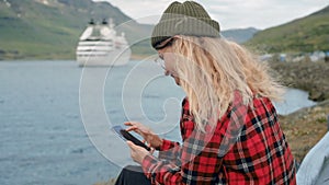 Young woman sits in port watch cruise ship leave