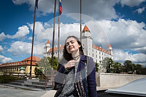 Young woman sits on square with a view on castle