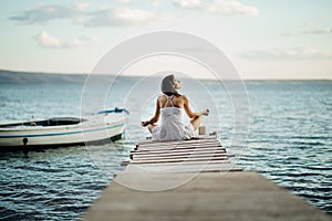 Young woman sitting alone at the beach.Self isolation in nature.Coronavirus quarantine lockdown beach trip.Going to the beach.