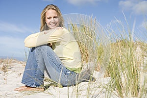 Young woman sitting amongst dunes