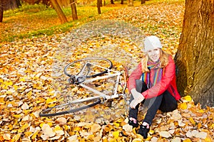 Young woman sitting in autumn leaves