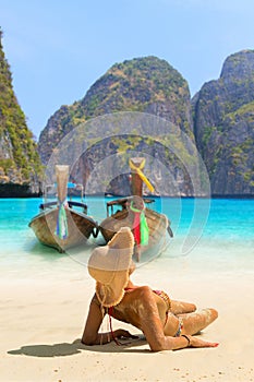 Young woman sitting on the beach at Maya Bay on Phi Phi Leh Island, Krabi Province, Thailand. Koh Phi Phi Leh is part of Mu Ko Ph