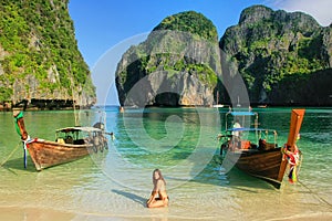 Young woman sitting on the beach at  Maya Bay on Phi Phi Leh Island, Krabi Province, Thailand