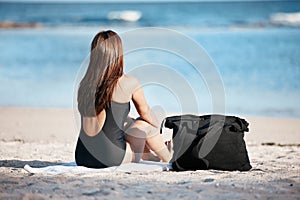 Young woman sitting on beach, peace by the ocean horizon on summer holiday and Mauritius vacation. Female tourist