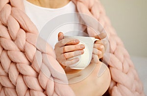 Young Woman Sitting on the Bed with Pink Giant Merino Wool Plaid Blanket