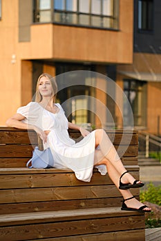 Young woman sitting on bench in residential area
