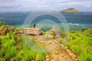 Young woman sitting on a bench at the viewpoint on Kanawa Island