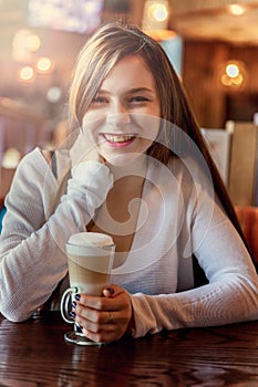 Young woman sitting in cafe with cup of coffe