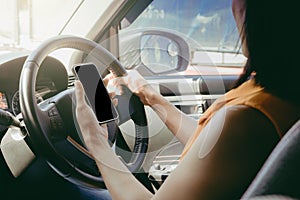 Young woman sitting in car and using her smartphone. transport warning and communication concept