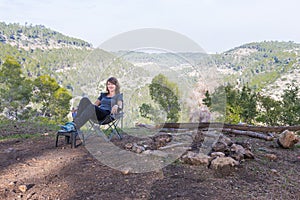 Young woman sitting chair in forest.