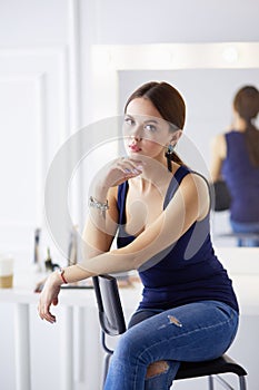 Young woman sitting on a chair isolated over white background