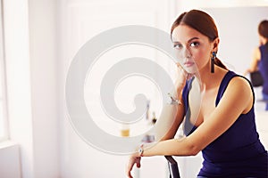 Young woman sitting on a chair isolated over white background