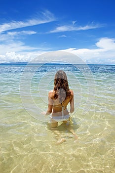 Young woman sitting in clear water on Taveuni Island, Fiji